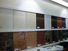 Mostruário de granitos: placas em pé numa parede do showroom, cada uma etiquetada