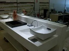 Showroom com bancada em pedra clara e cubas de apoio expostas