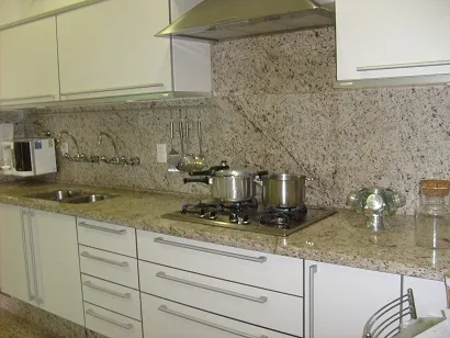 Cozinha com bancada e frontão em granito branco pintalgado