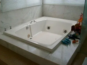 Banheira de hidromassagem embutida em deck de mármore branco