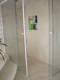 Box de banheiro com parede revestida em mármore bege claro
