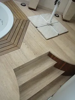 Piso de travertino romano com faixas escuras e degrau